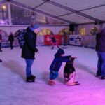 Kind mit Pinguin auf Eisfläche